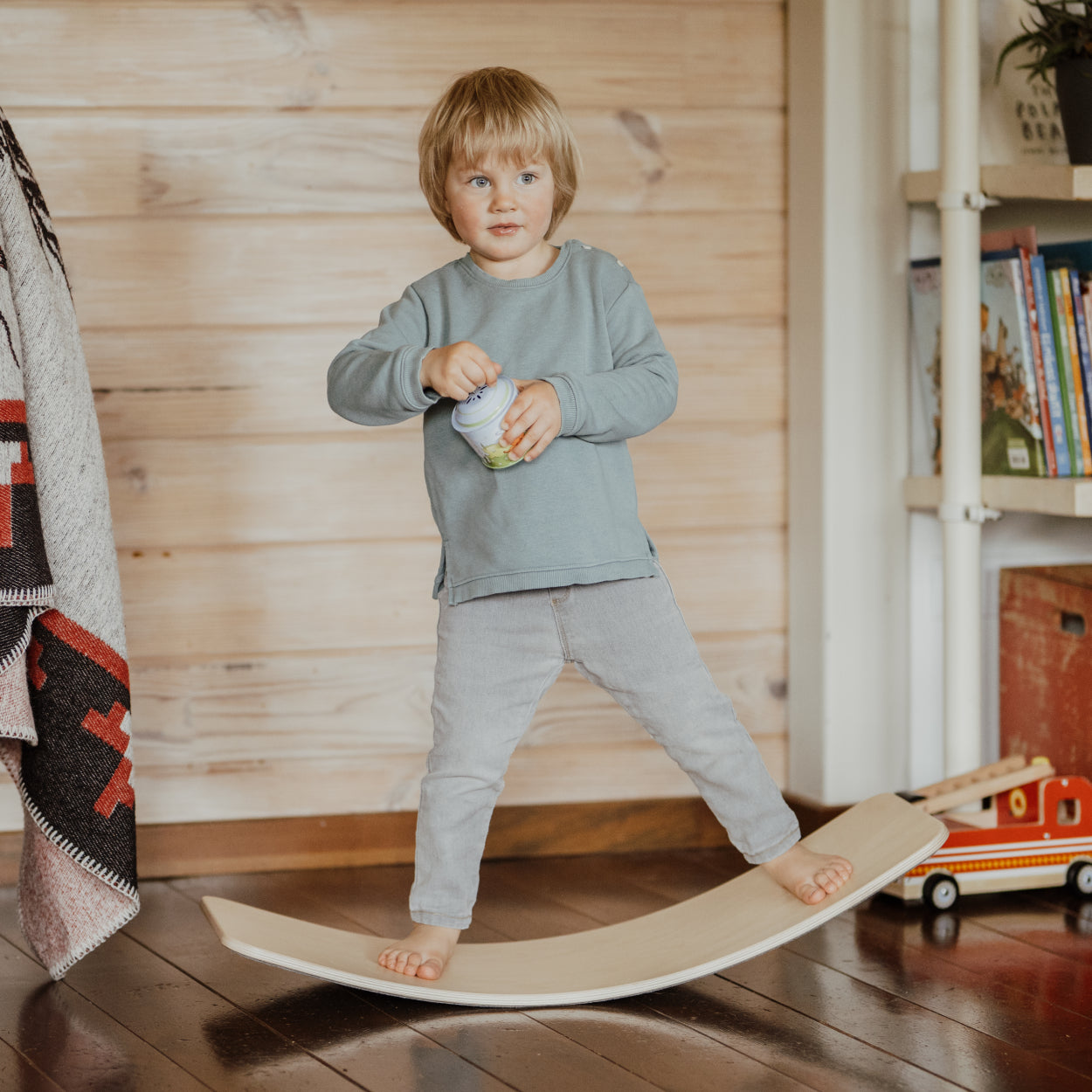 Child balancing on wobbly board.