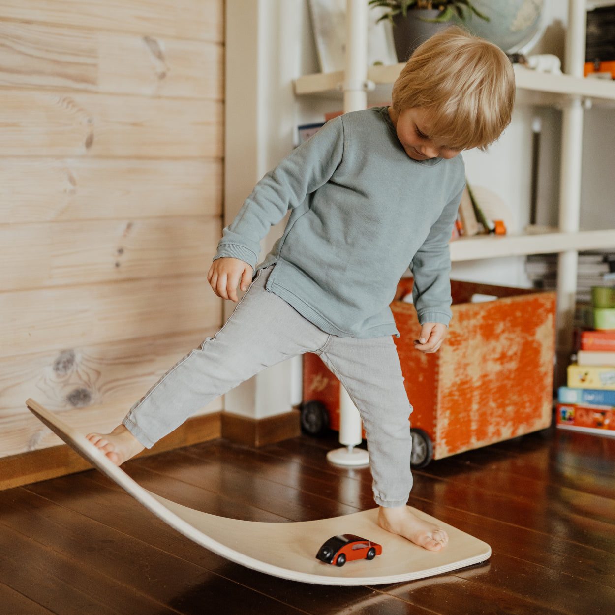 Boy playing on top of wooden plywood balance board