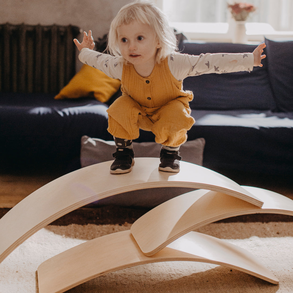 Child balancing on multiple stacked balance boards showcasing size differences.