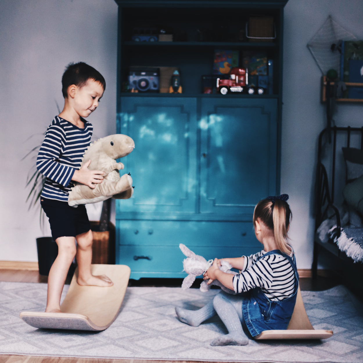 Pre-scoolers playing on wooden balance boards with soft material bottom.