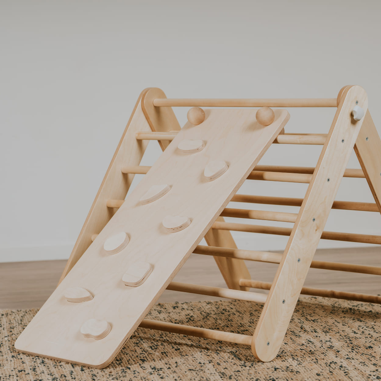 Leg&go birch plywood climbing triangle in natural wood color with a ramp attached to it.