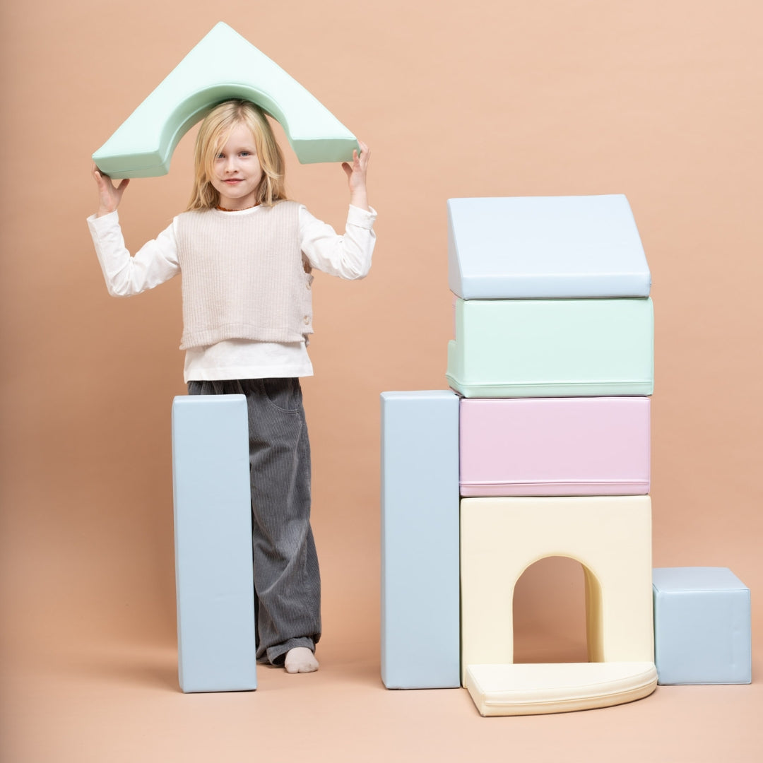 Child playing with tall stacked pastel soft play blocks from Creativity set