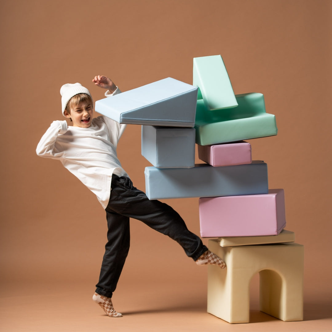 Boy playing with large pastel-colored soft play blocks from the Creativity set