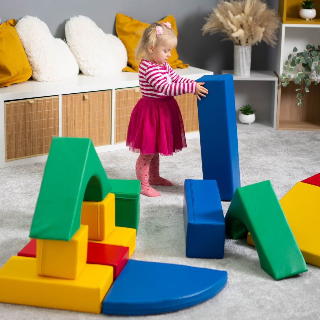 Girl playing on colorful Creativity set with stacked foam blocks and climbing shapes