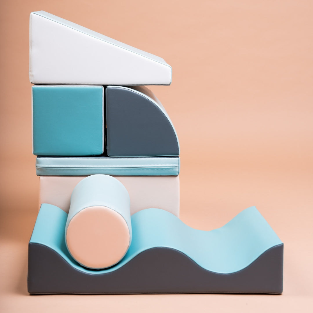 Discoverer soft foam blocks in light pastel tones stacked vertically with wave-shaped base
