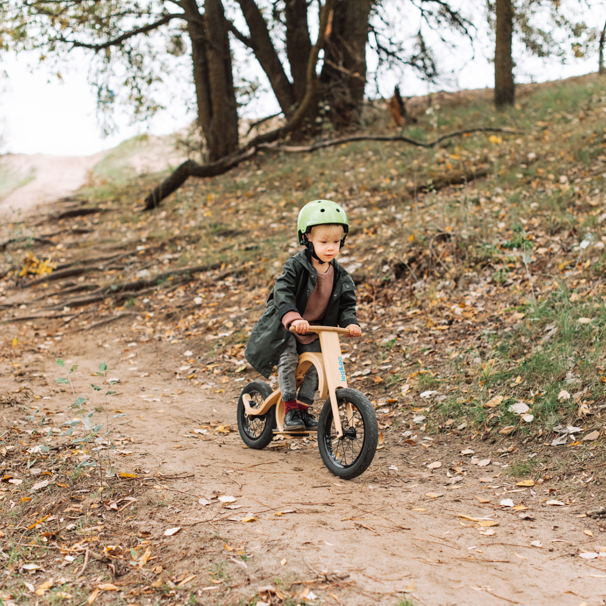 Boy standing on balance bike while going down the road