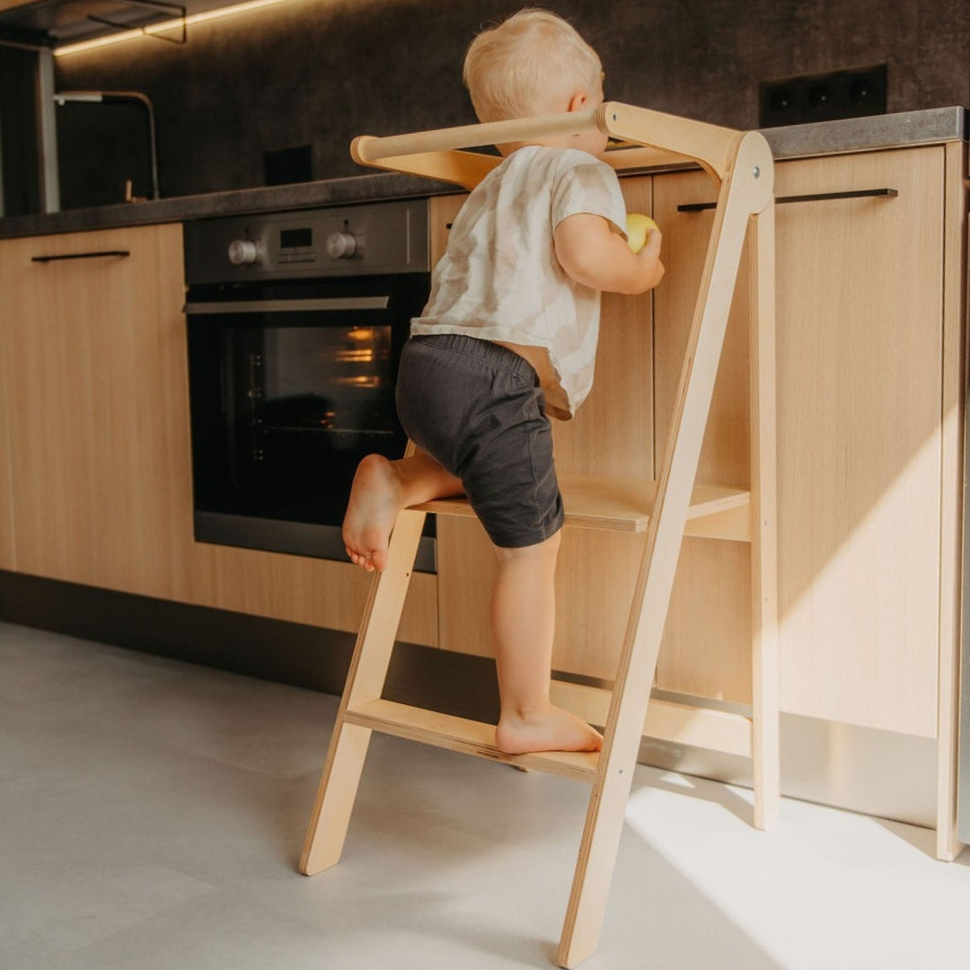 Child climbing on Leg&Go Foldable Helper Tower Natural to reach kitchen counter safely