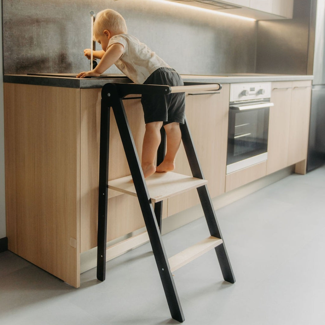 Boy reaching water faucet using Leg&Go Foldable Helper Tower black