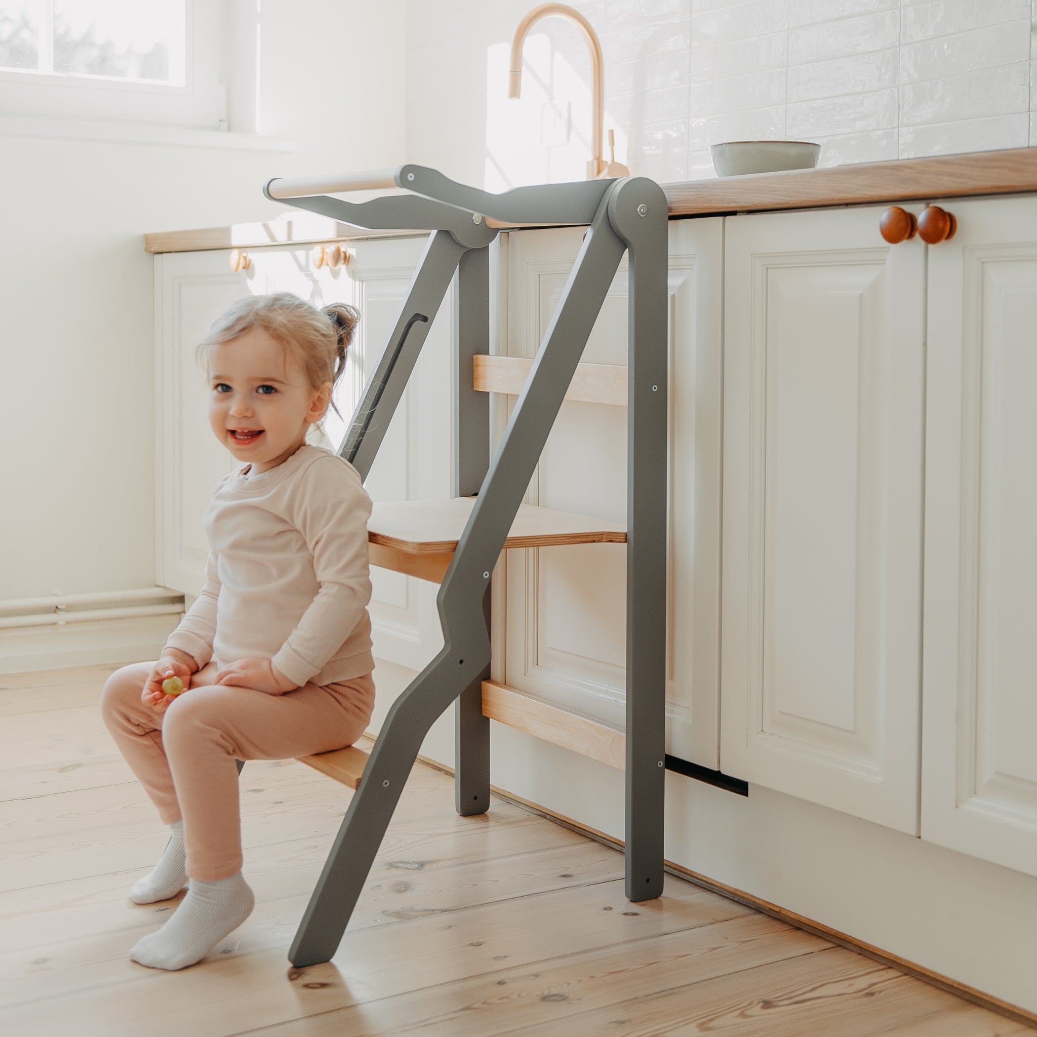 gray foldable helper tower with safety rail for toddlers