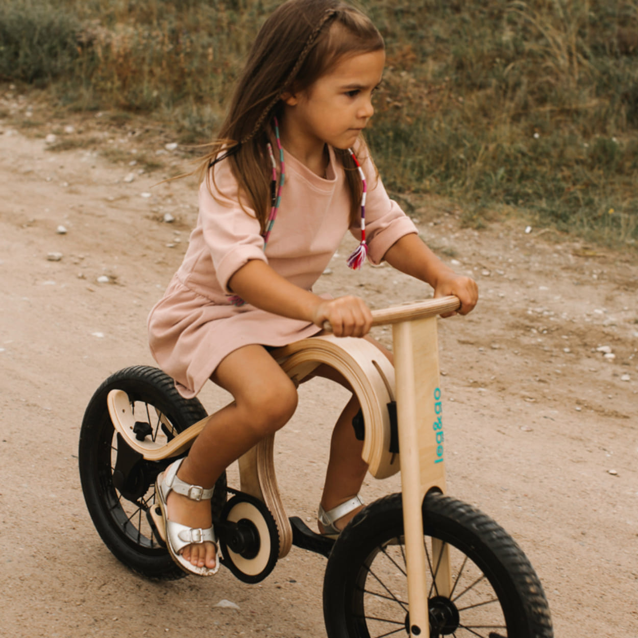 girl riding legandgo wooden balance bike with pedal add on