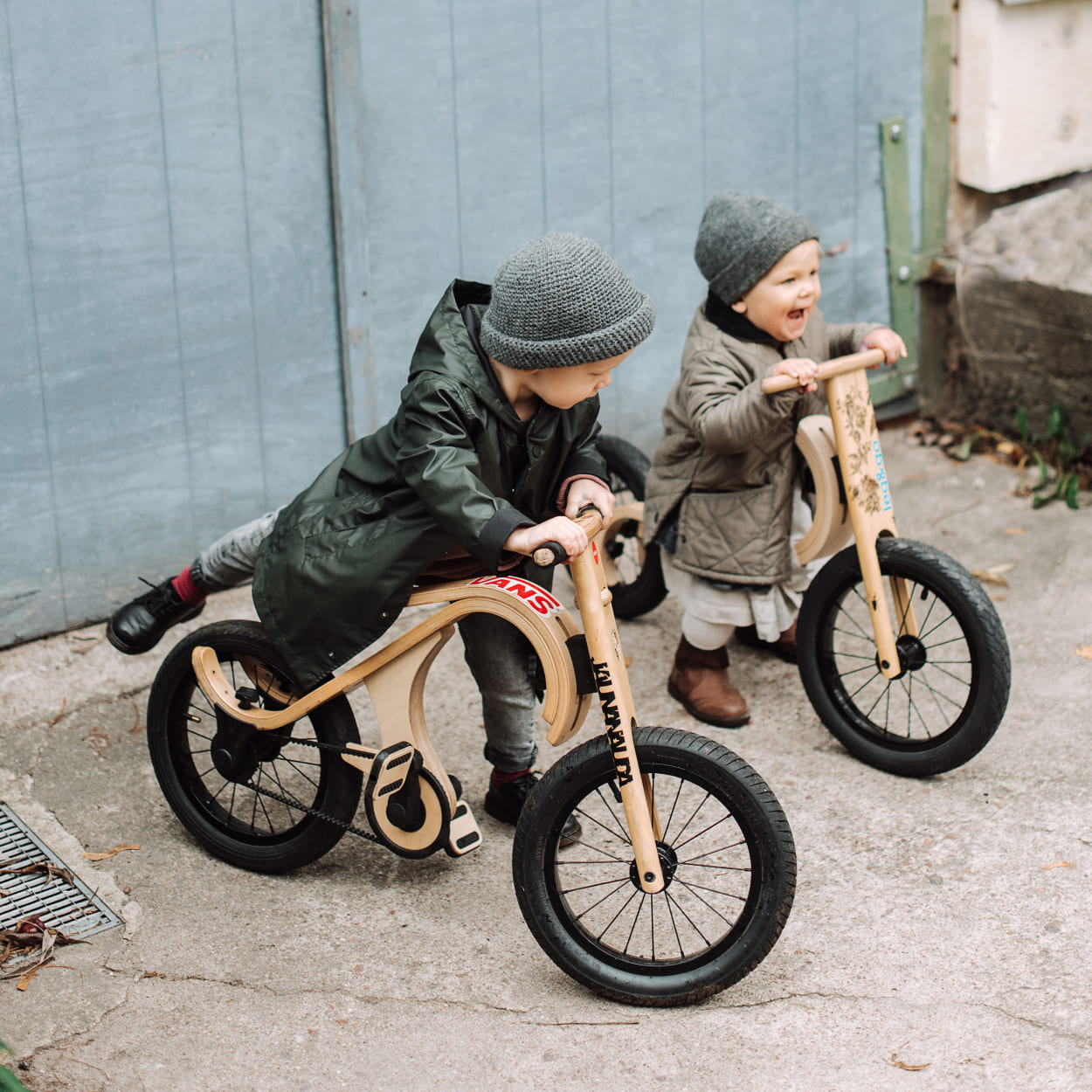 children racing on wooden pedal bike and balance bike