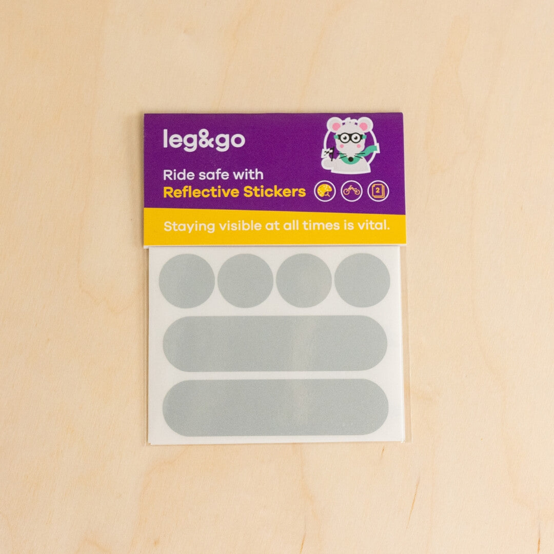 Pack of reflective stickers with 'leg&go' branding on a wooden surface