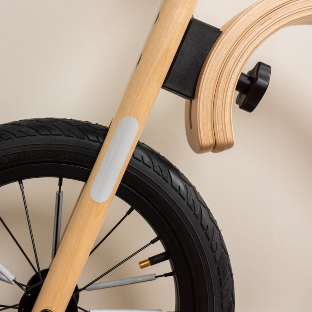 Leg&Go balance bike with reflective stickers on wooden frame for improved safety in low light