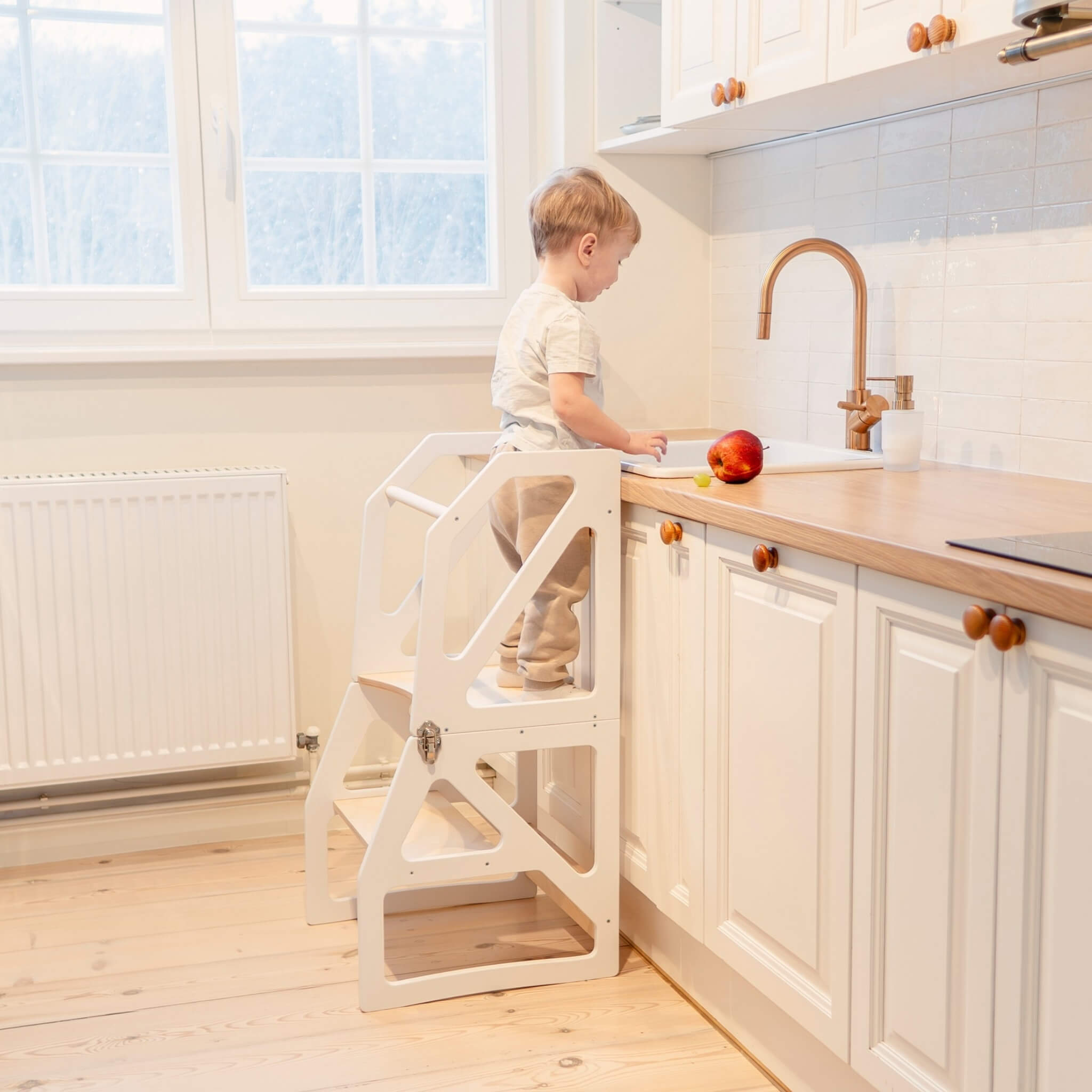 Wood convertible kitchen tower used as adjustable learning stool at counter