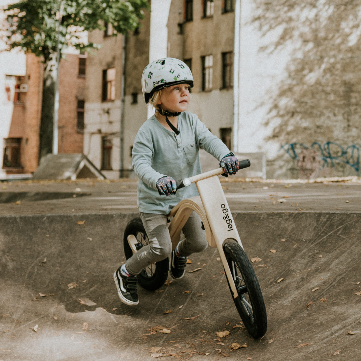 Child riding wooden balance bike on a ramp