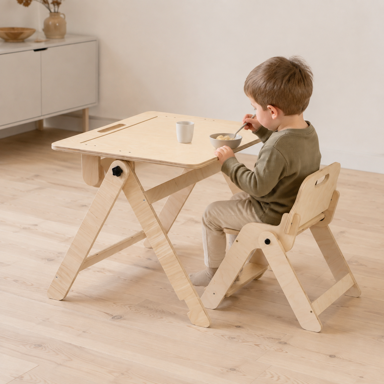 Child drawing on an inclined kids art table while sitting on a matching chair