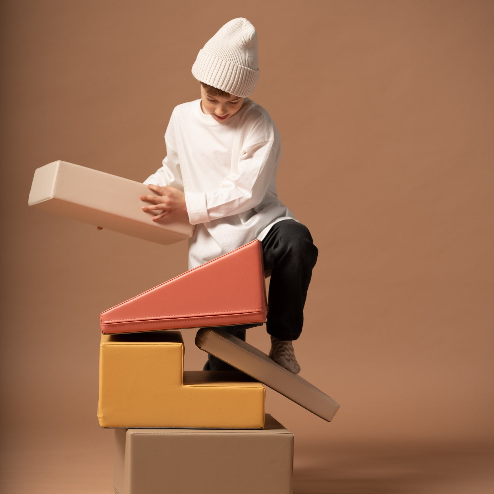 Soft play corner climber set in use with a child sitting and balancing on blocks