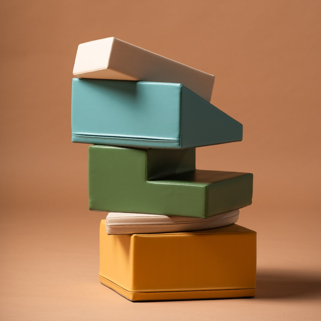 Soft play blocks stacked into a tower using the beige and turquoise corner climber foam set