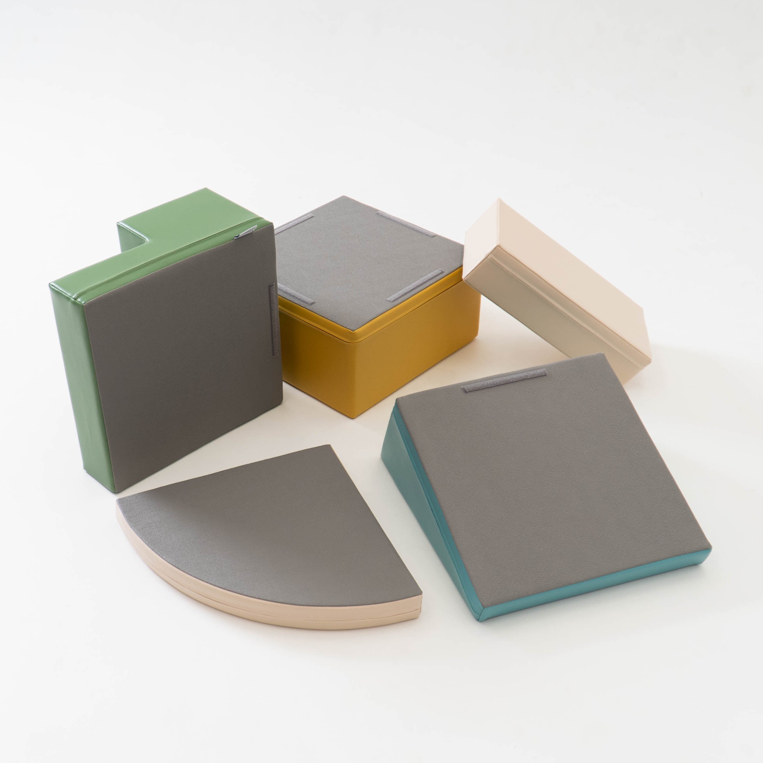 Bottom view of beige and turquoise soft foam blocks, showing non-slip surface design and material texture