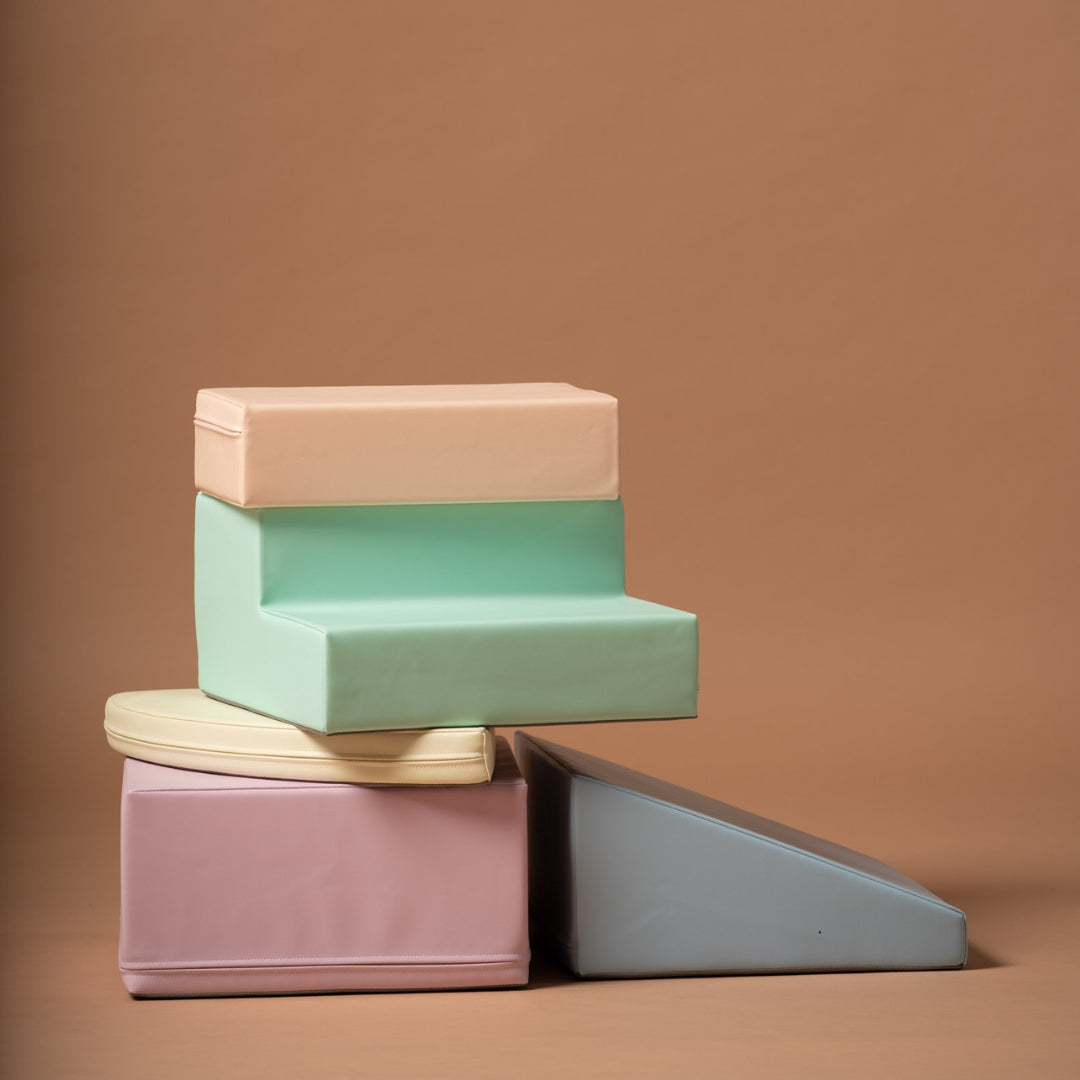 Stacked pastel soft play blocks in a corner climber set, showing colorful foam shapes against beige background