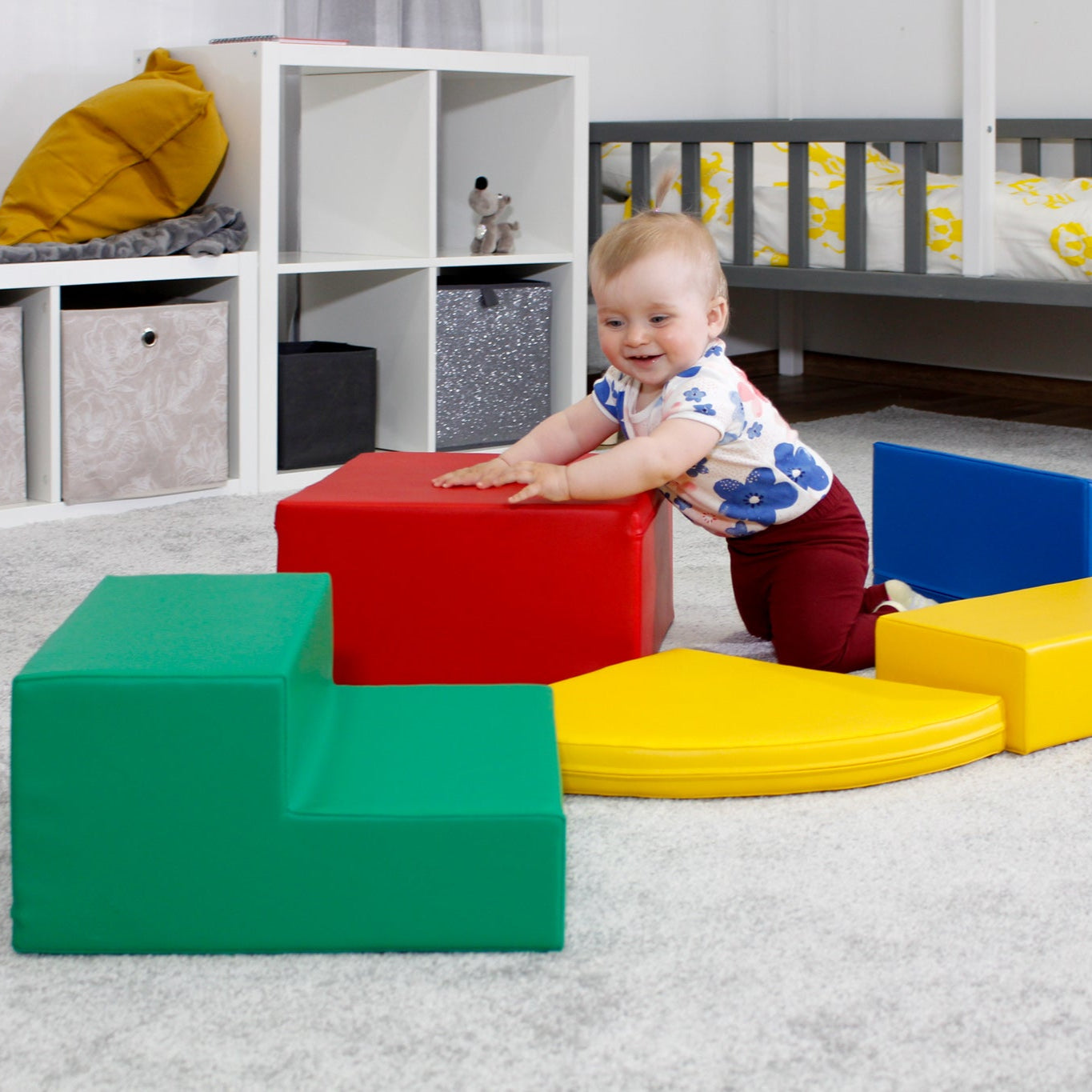 Child balancing and playing on a multicolor soft play corner climber set in a nursery setting