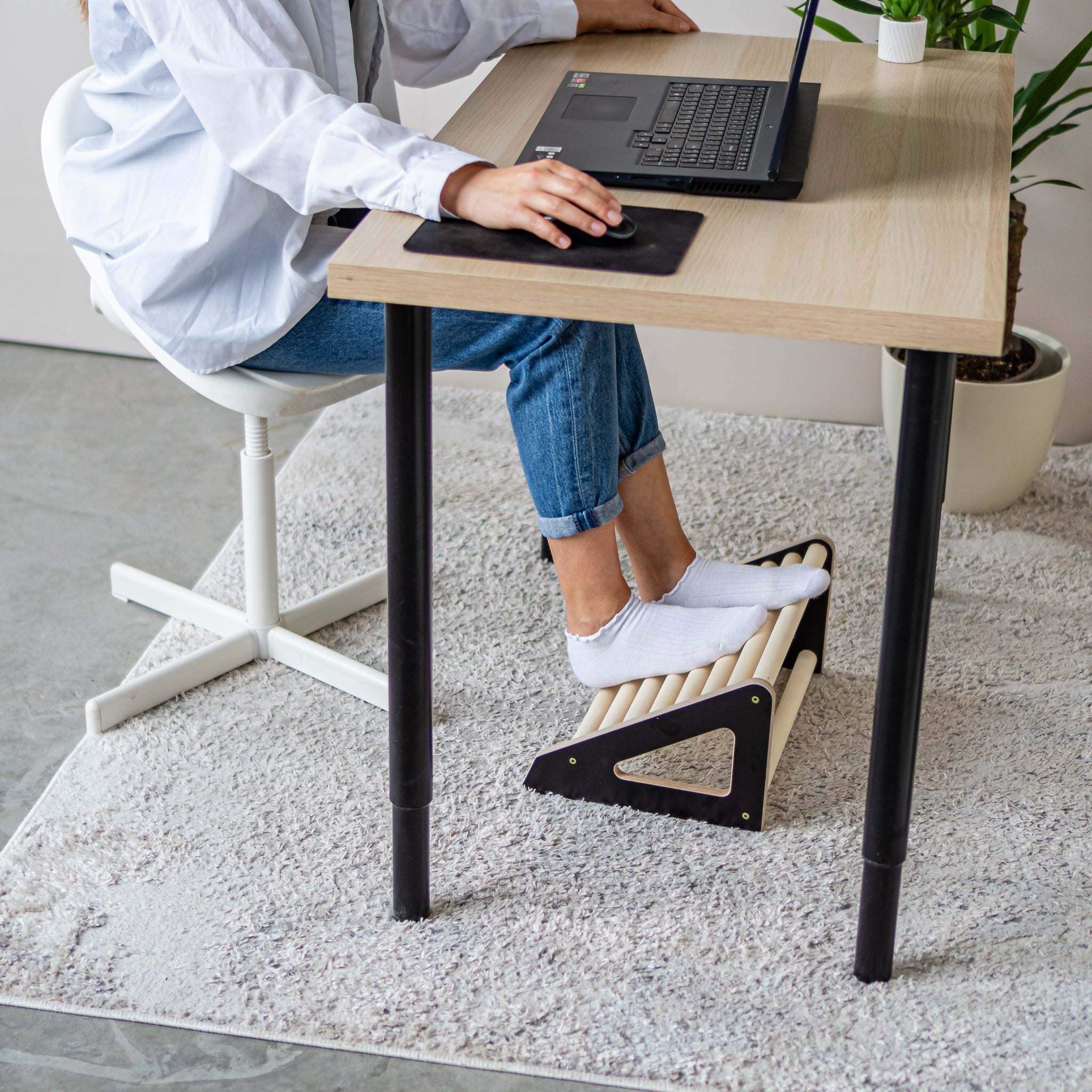 Under desk wooden footrest roller in a modern home office