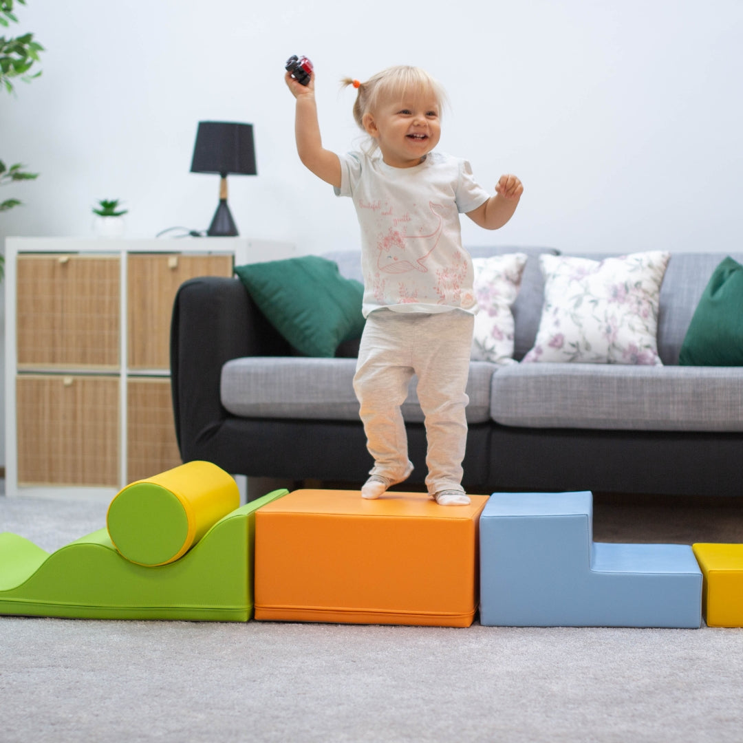 Girl playing on Explorer light multicolor soft blocks set arranged in living room