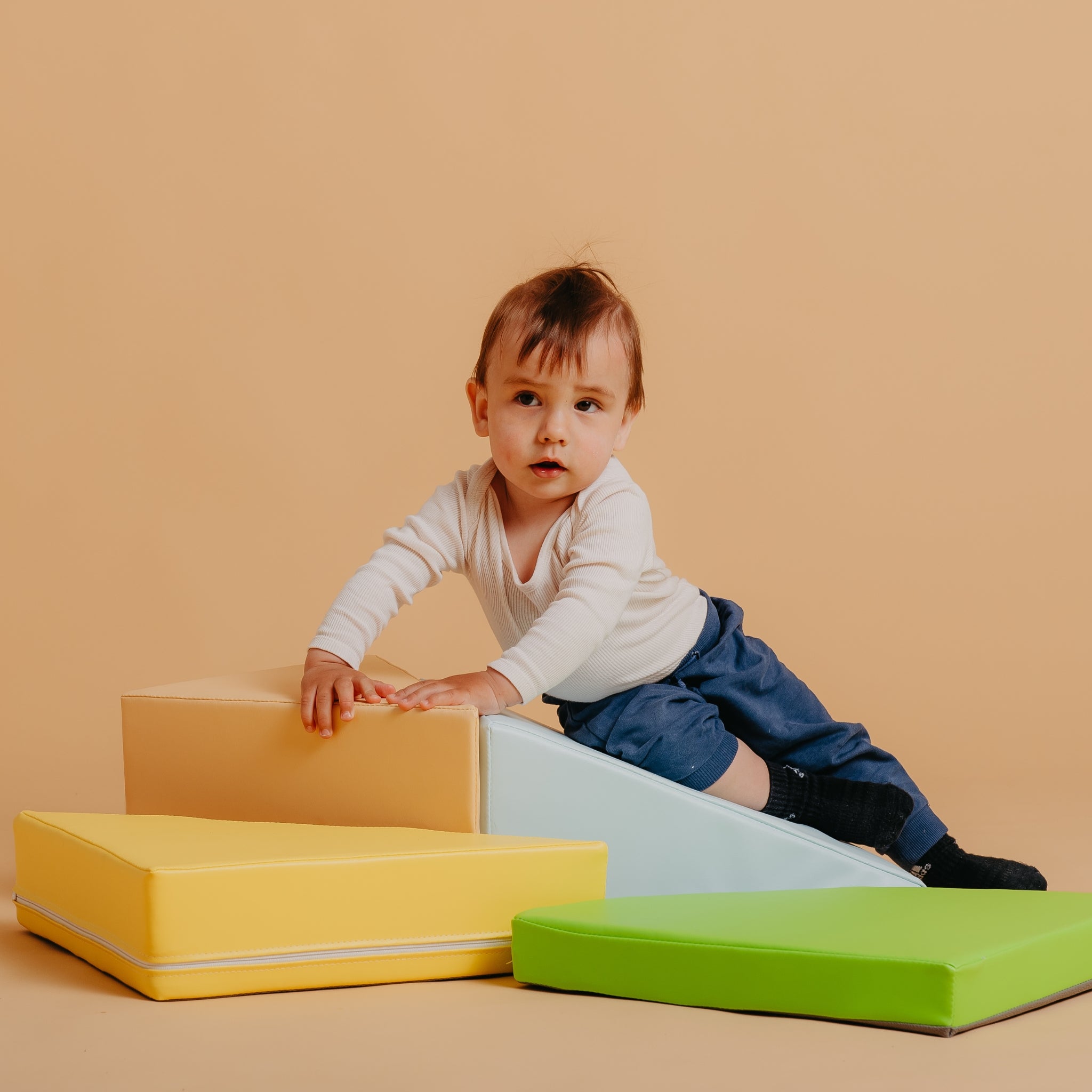 Child creating imaginative structures with Kubo Blocks Lumo soft play blocks for sensory and educational play
