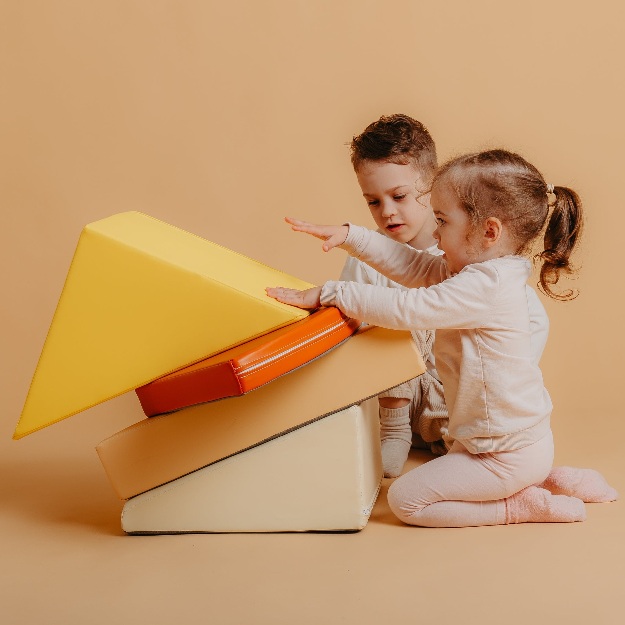 Child exploring Kubo Blocks Lumo orange foam climbing blocks for balance, coordination and imaginative play