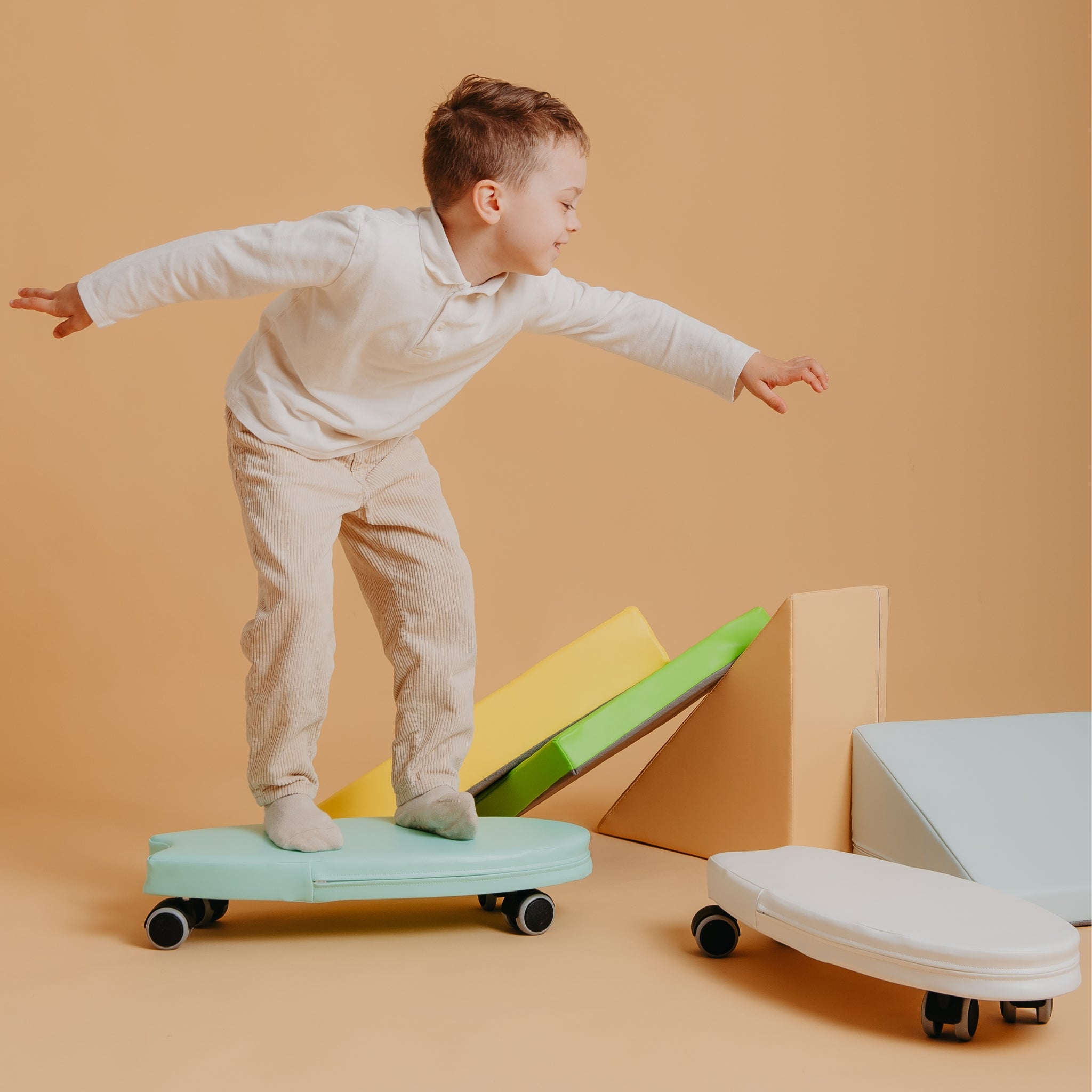 Toddler balancing on Kubo Blocks Lumo soft play set and ride on surfer toy