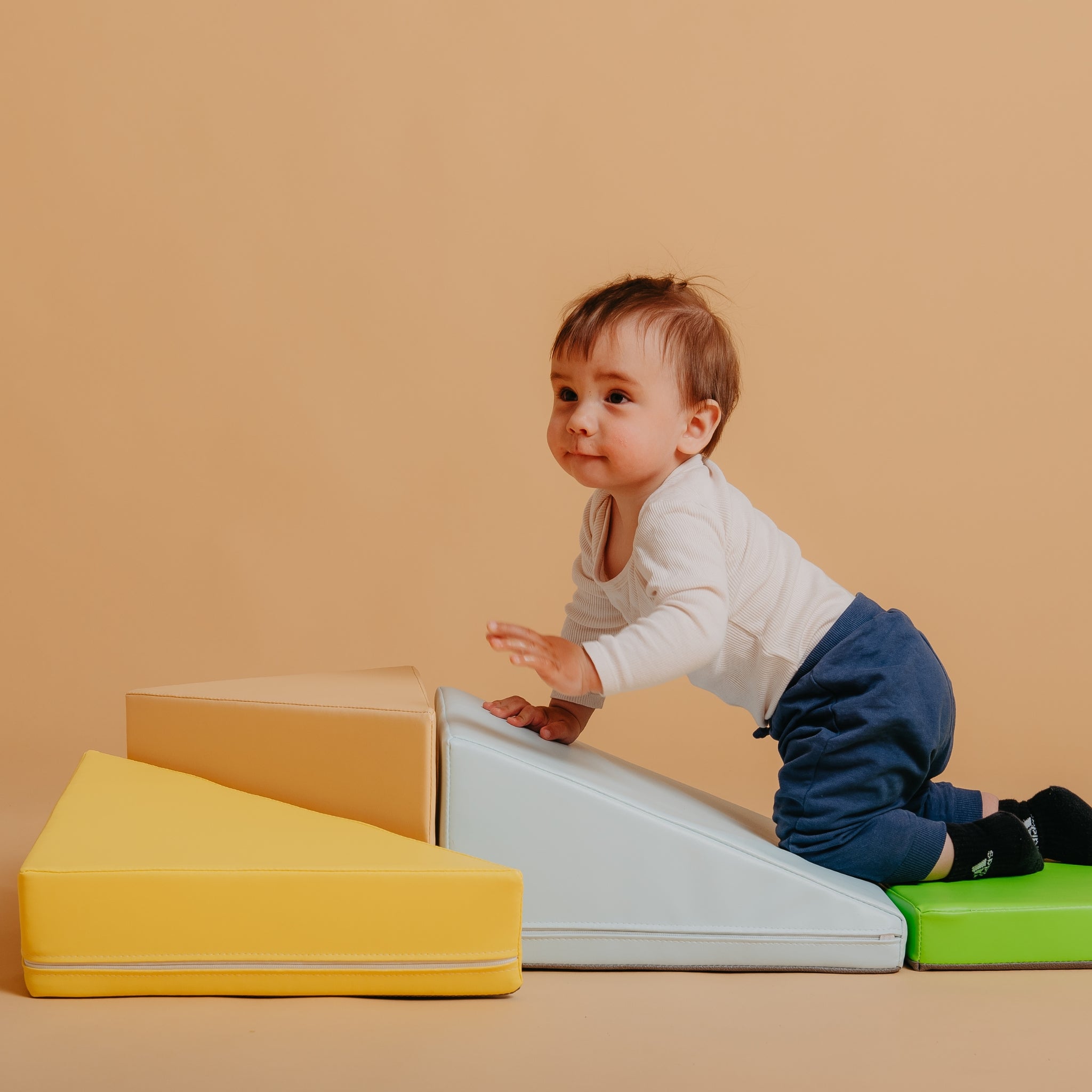 Toddler playing with Kubo Blocks Lumo soft play set featuring foam climbing blocks for balance and motor skill development