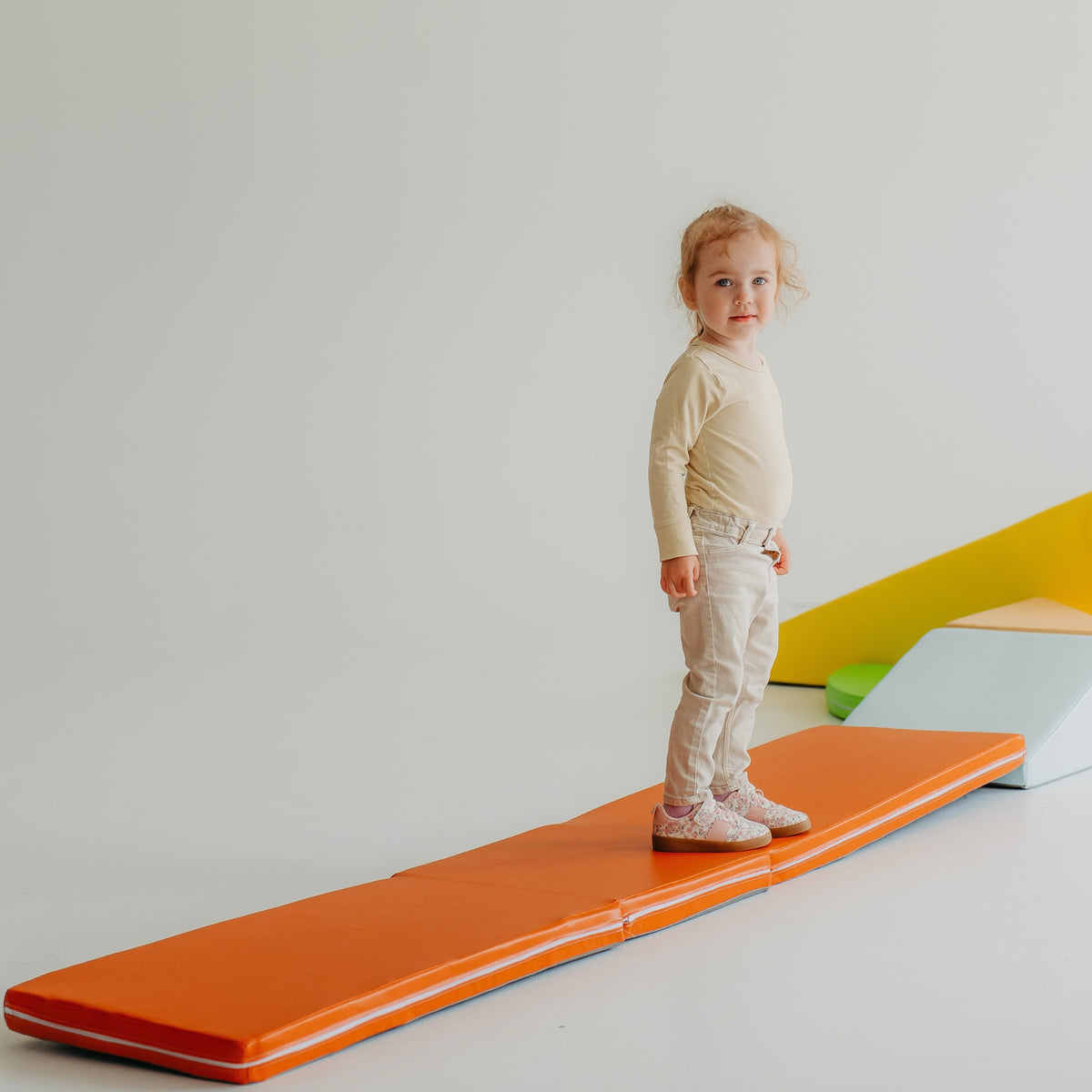 Child practising balance and gross motor skills on the Kubo Blocks MATO foldable play mat
