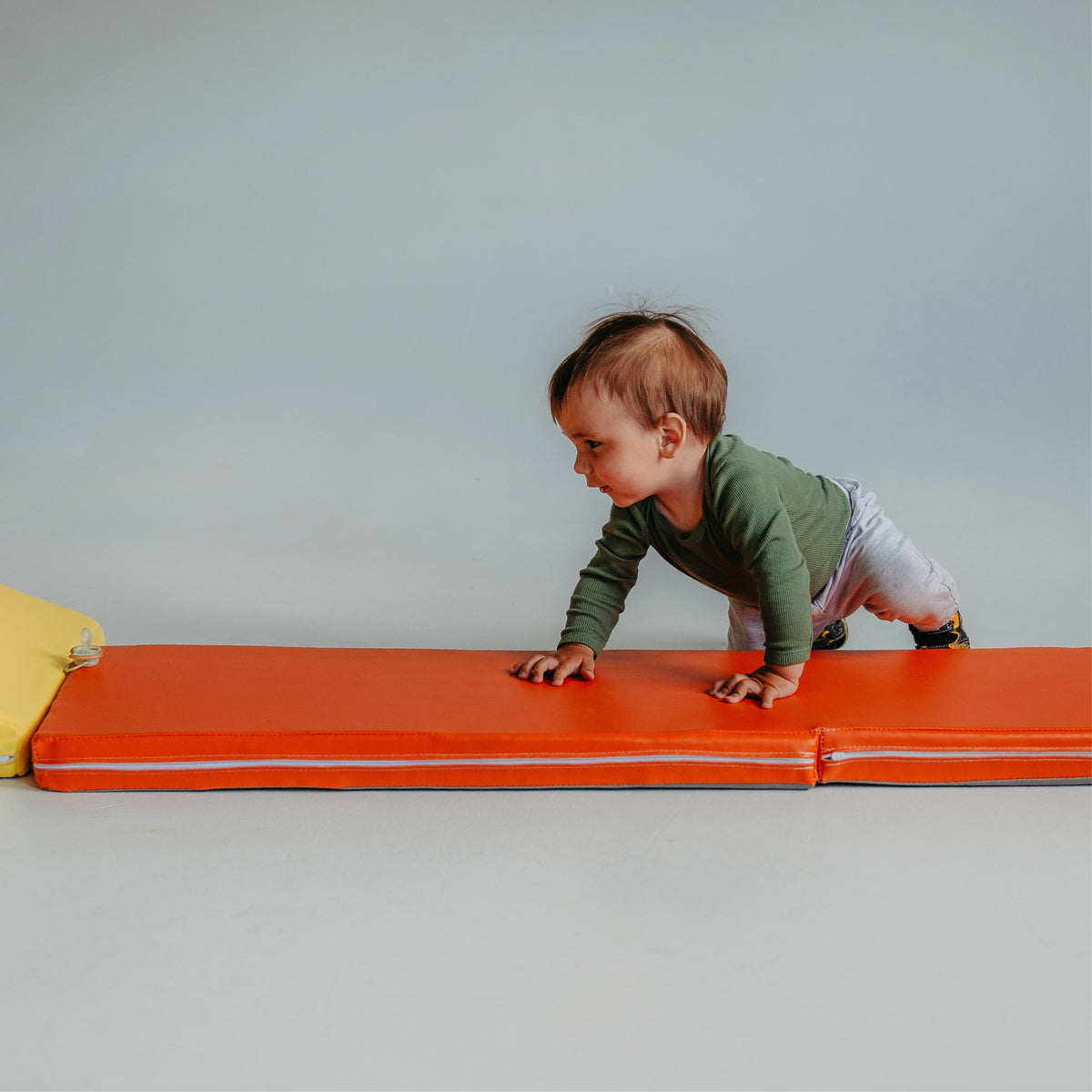 Toddler crawling across the orange Kubo Blocks MATO soft foam play mat