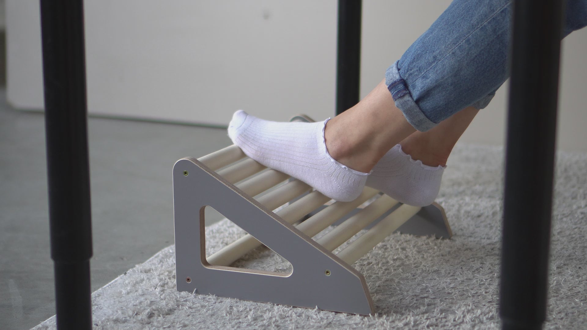 Wooden Footrest Roller shown in use under a desk to promote movement, comfort, and ergonomic support while sitting