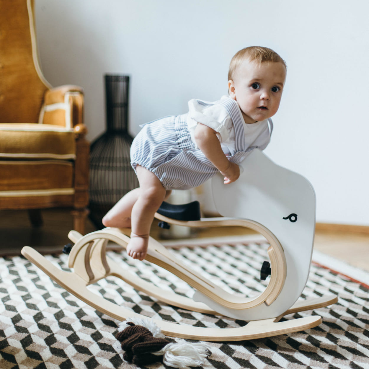 child standing on the leg&go rocking elephant toy.
