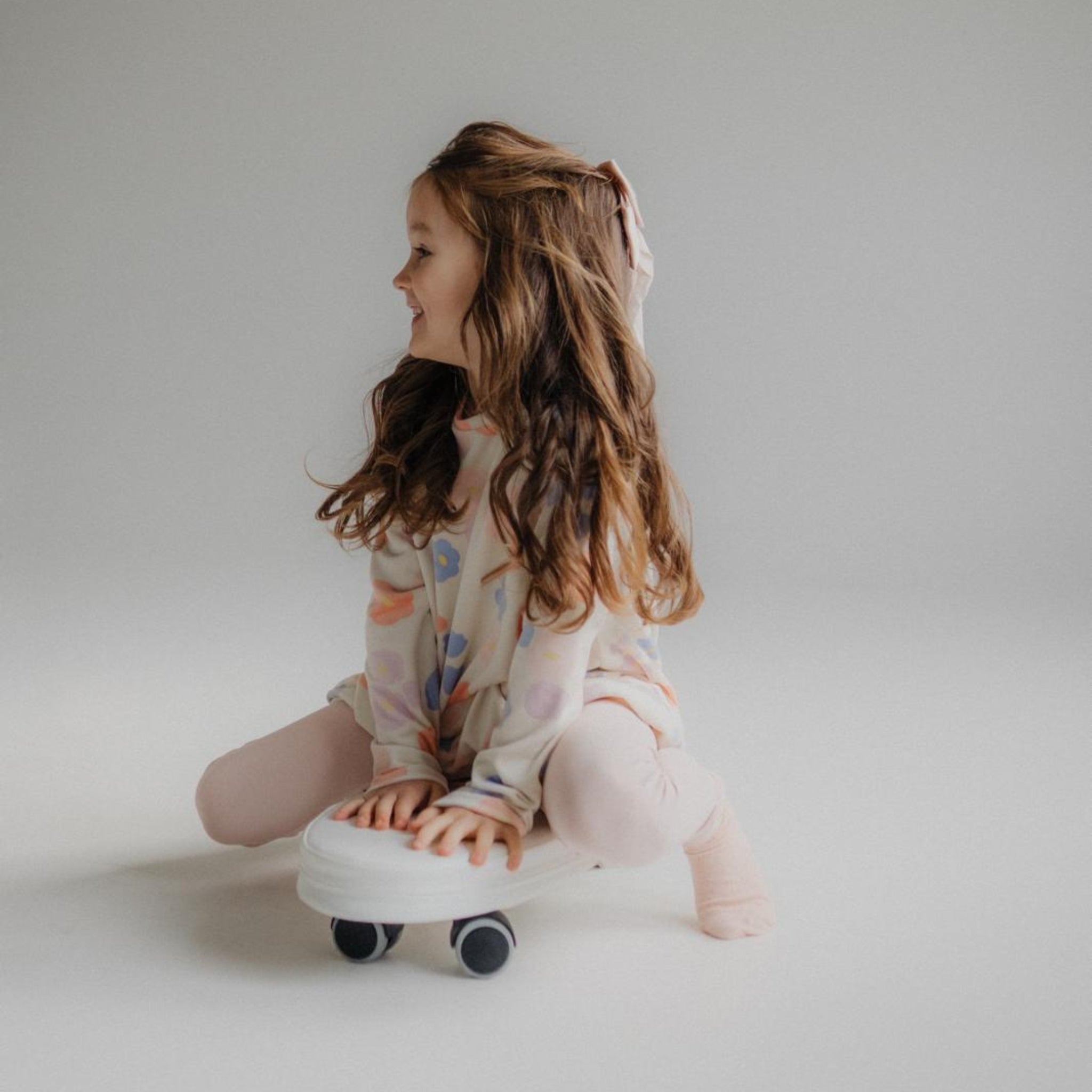 Girl playing with soft surf ride on toy on wheels indoor active play toy