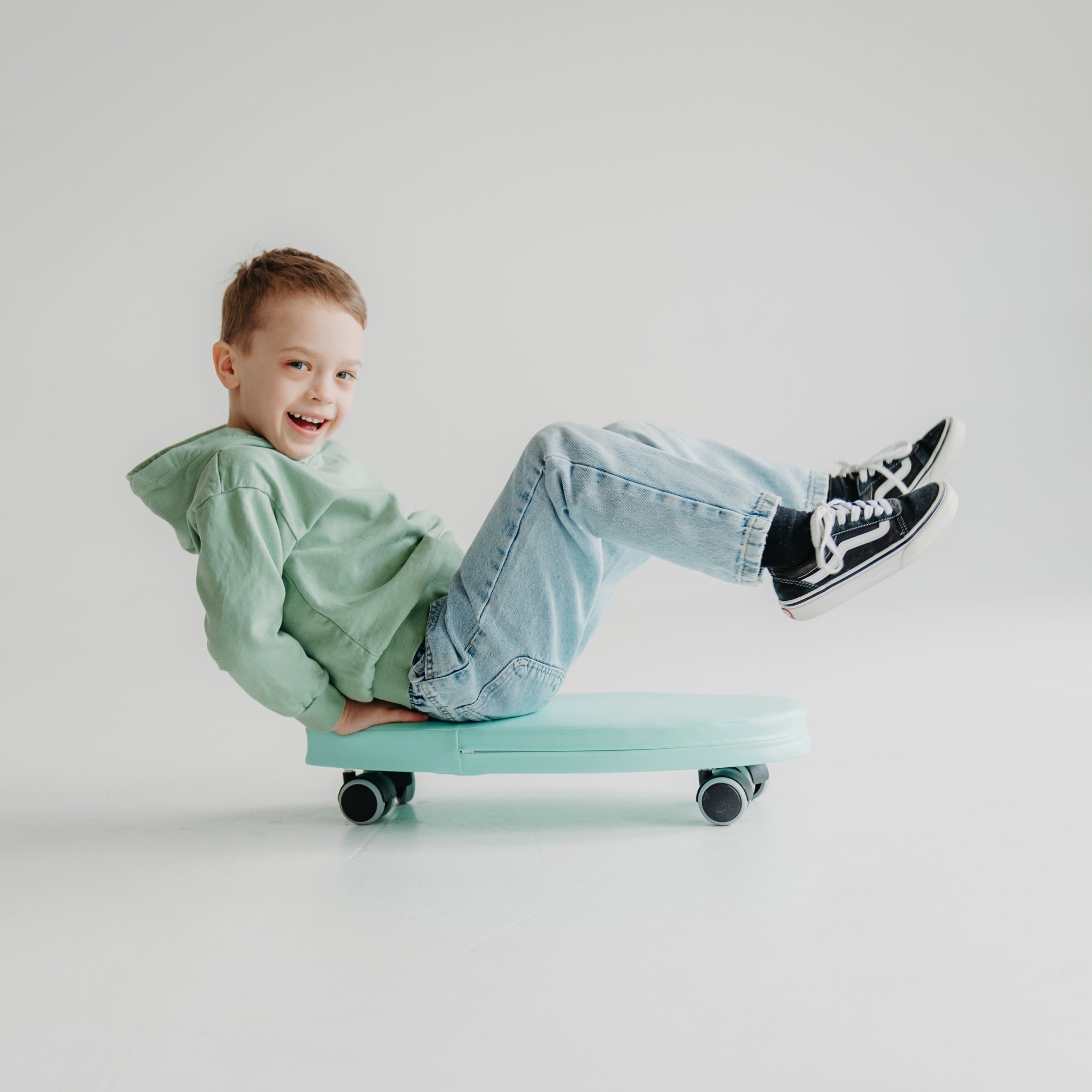 Child riding green foam surf ride on toy, lightweight indoor ride-on for active play
