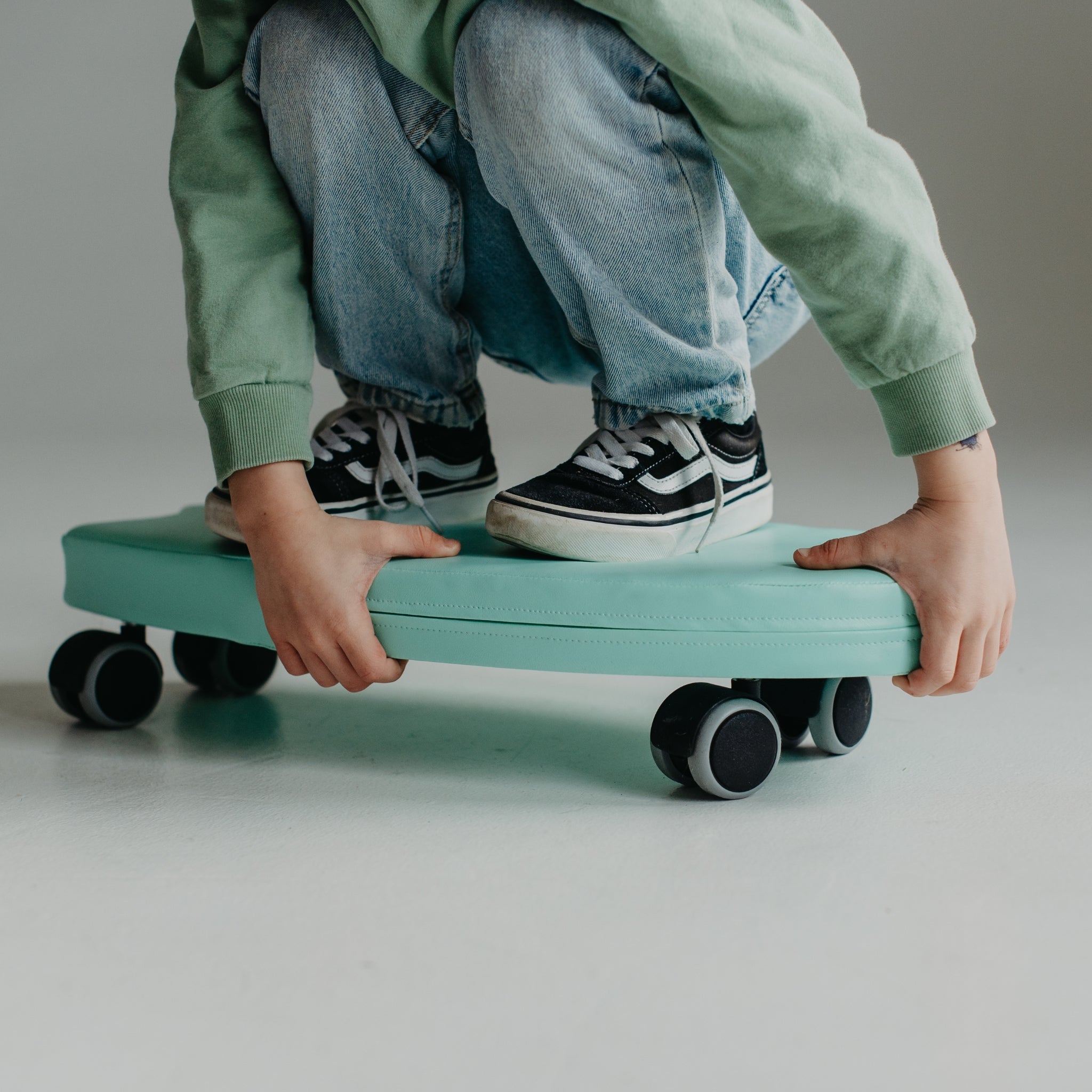 Close-up of green foam surf ride on toy with wheels, soft indoor play equipment
