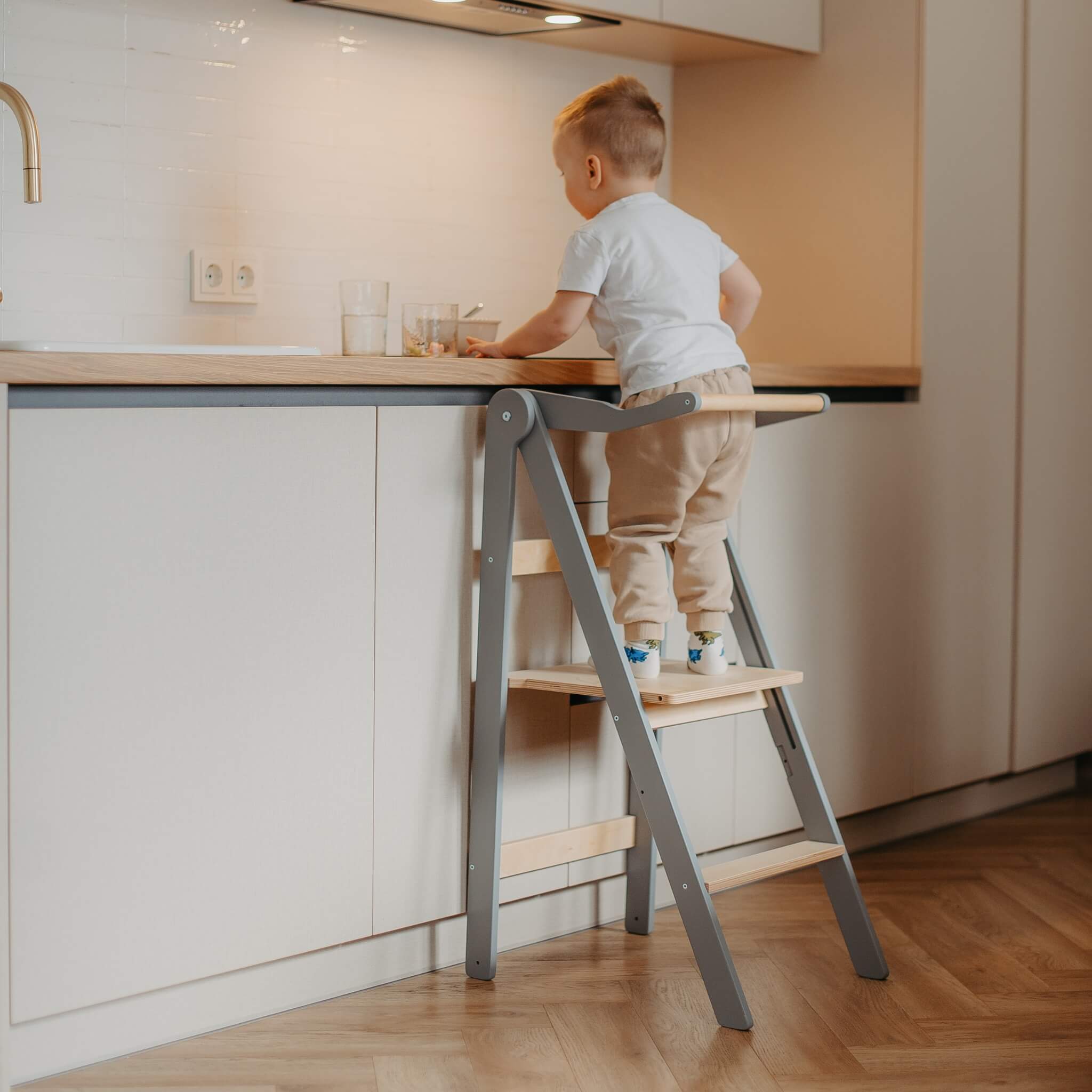 Child using foldable learning tower to reach sink