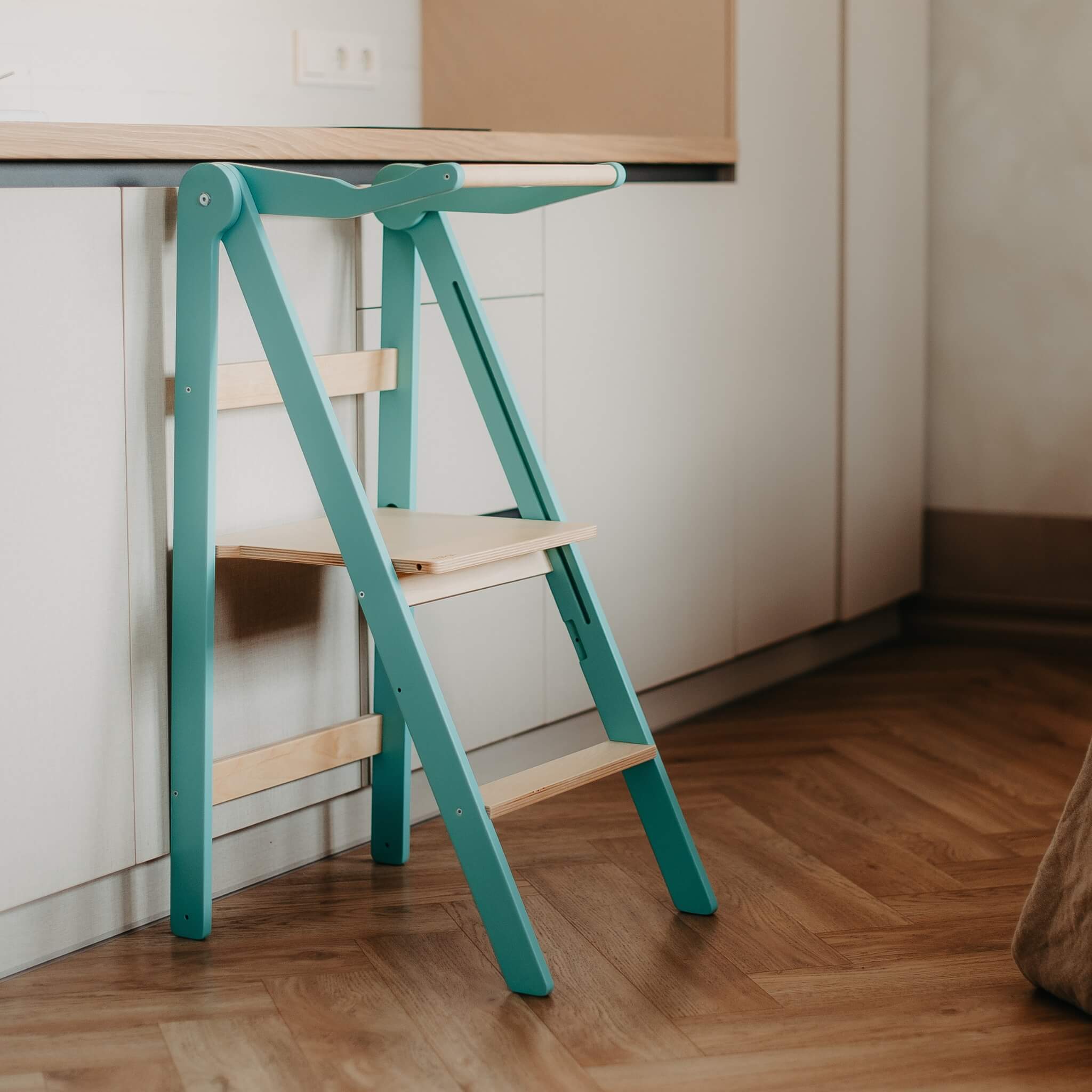 Turquoise foldable learning tower in modern home interior setup